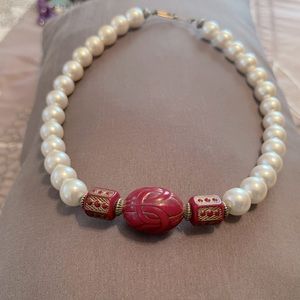 Pearls with red decorative clay ornaments.
